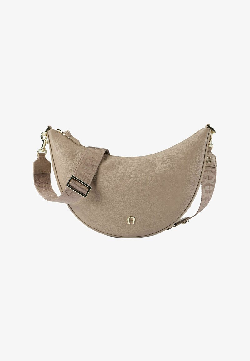 Sac bandoulière en cuir beige avec une forme incurvée, une surface texturée, et une sangle à motif ornée d'accents métalliques dorés.