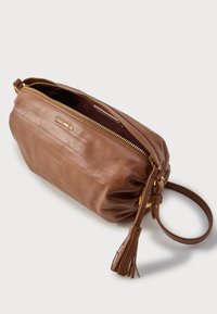 Καφέ δερμάτινη τσάντα με ανάγλυφες ρίγες, χρυστό φερμουάρ και αποσπώμενη λαβή. Διαθέτει διακοσμητικό κρόσσι στο πλάι.