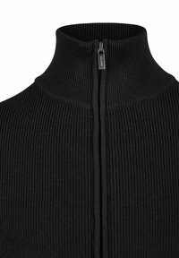 Schwarzer gerippter High-Neck-Pullover mit einem Reißverschlussdetail vorne. Weicher Stoff mit einer figurschmeichelnden Form und subtilen vertikalen Linien.
