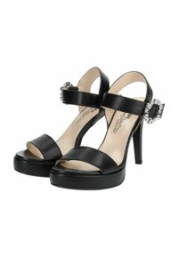 Sandales noires à talons hauts avec une finition en cuir lisse, semelle à plateforme et une bride de cheville réglable ornée d'un accent en cristal.