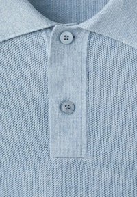 Jasnoniebieska koszulka polo z teksturowaną tkaniną, dwoma guzikami przy kołnierzyku oraz gładkim splotem w górnej części.