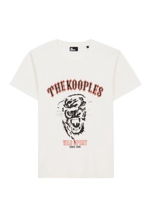 T-shirt blanc avec texte noir et rouge "THE KOOPLES" et "WILD SPIRIT SINCE 2008" entourant une illustration d'une tête de tigre rugissante.