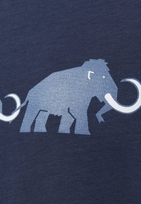 Un tessuto blu navy presenta una grafica di un mammut in azzurro chiaro e bianco. Il design mette in evidenza la forma dell'animale e le sue zanne prominenti.