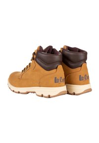 Stivali da trekking in pelle marrone con colletto imbottito, design con lacci e suola in gomma. Presenta il logo sul tallone e accenti in contrasto color beige.