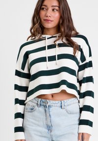Hoodie court avec des rayures horizontales vertes et blanches, en matériau léger, avec cordon de serrage ajustable, associé à un jean en denim clair à taille haute.