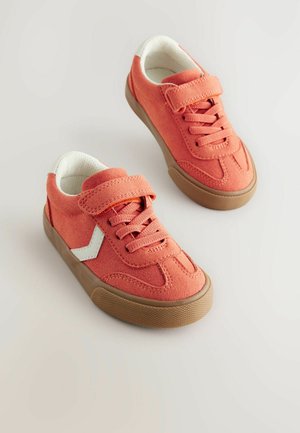 Sneaker in tela arancione con dettagli bianchi, punta rotonda, suola in gomma testurizzata e cinturino con strappo. Lacci inclusi per la regolazione della vestibilità.