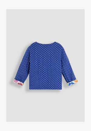 Zila garo piedurkņu krekls ar baltām punktiņām, ar puķu raksta aprocēm. Apaļa kakla izgriezuma un brīva piegriezuma dizains.