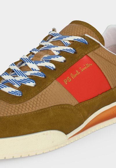 Καφέ και καμηλό αθλητικό παπούτσι με μπλε και λευκά κορδόνια, κόκκινο πλαϊνό πάνελ με «PS Paul Smith» σε χρυσό, υφασμένο πάνω μέρος και λευκή σόλα με πορτοκαλί λεπτομέρεια.