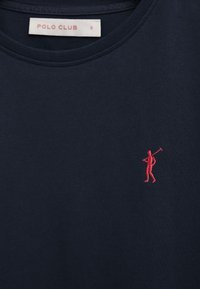 Mørkeblå t-shirt med lille rød broderet polo-spiller logo på brystet og hvid "POLO CLUB S" etiket inde i halsudskæringen.