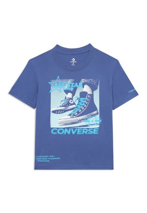 T-shirt bleu à manches courtes avec un graphique de basket Converse All Star montante, logo étoile et texte "Créé en 1908 / Marque déposée / Mondial."