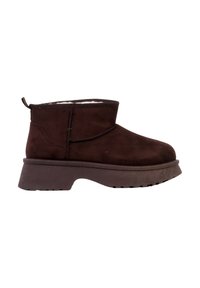 Bottine en daim marron avec bout arrondi, semelle texturée et talon plat à plateforme. Intérieur doublé et languette arrière pour faciliter l'enfilage.