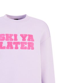 Sudadera lila con texto bordado en rosa que dice "SKI YA LATER", con un cuello redondo y un corte relajado. Textura de tela suave.