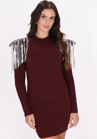 Bordeaux geribbelde trui-jurk met lange mouwen, voorzien van metalen zilveren franjes op de schouders voor extra textuur en visuele interesse.