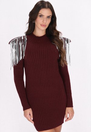 Burgundy bordás pulóverruha hosszú ujjal, fémes ezüst frufru díszítéssel a vállakon, amely extra textúrát és vizuális érdekességet ad.