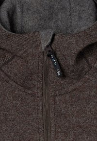 Brun zip-up hoodie lavet af struktureret stof, med en kontrasterende lys grå inderside og en logo-præget lynlåsgriber med dekorative detaljer.
