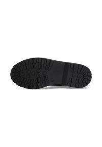 Suela de zapato de goma negra con surcos profundos y diversos patrones, que presenta indentaciones circulares y rectangulares para mayor agarre.