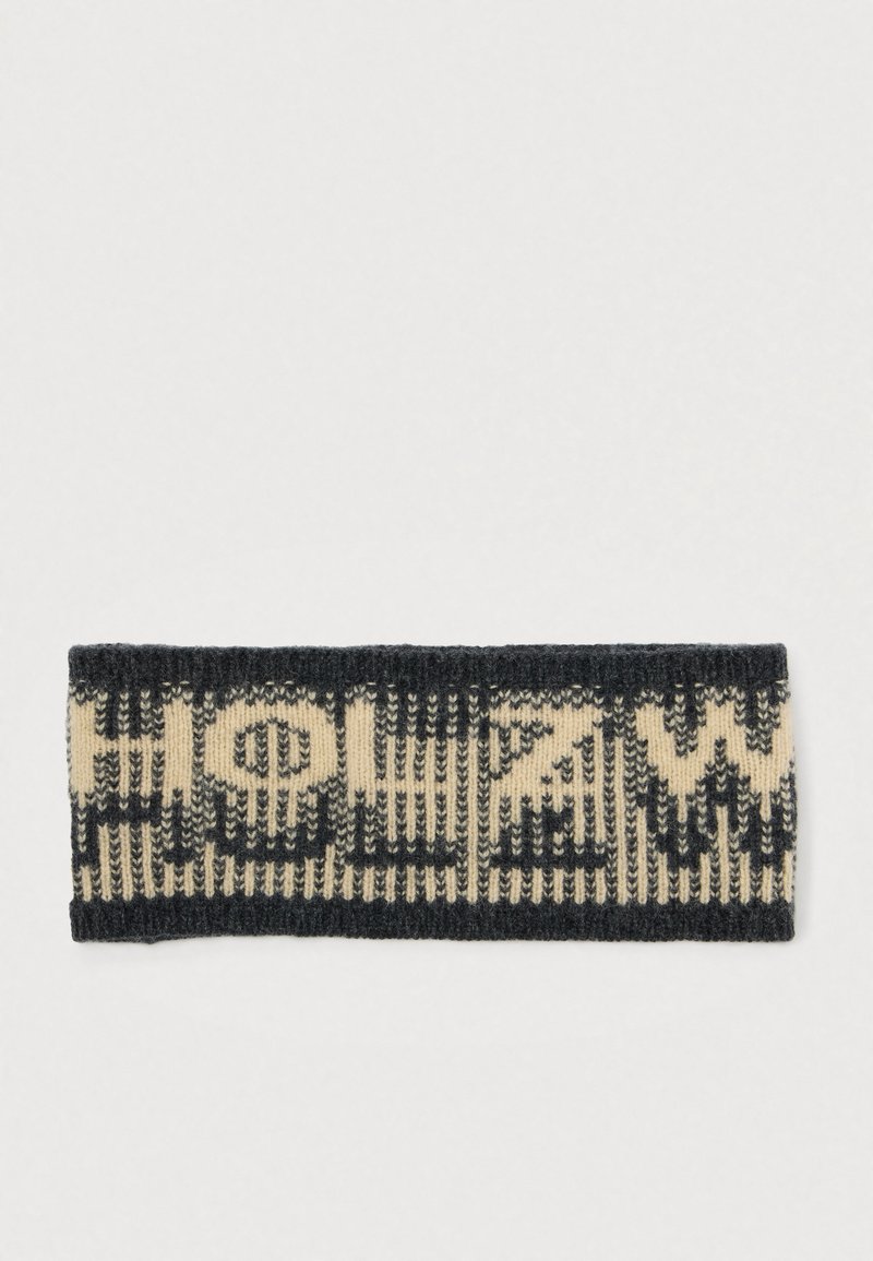 Un bandeau en tricot présentant un schéma de couleurs contrasté noir et beige avec un motif géométrique. Le texte est intégré dans le design.