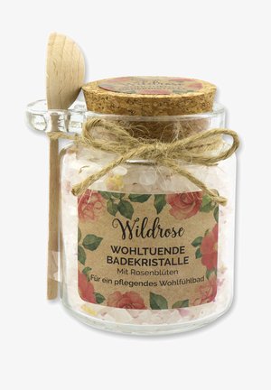 Glasjar mit Badekrystallen in rosa und weißen Flakes, Korkdeckel und einem Holzlöffel, mit Schnur gebunden. Florale Etikettendetails.