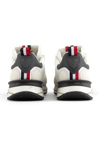 Skor med en vit ovandel, grå detaljer och en randig hälflik i rött, vitt och blått; märkta med "ROSSIGNOL" på hälen.