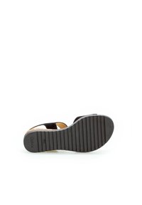 Zwarte sandaal met een textuur rubberen zool, bovenwerk van suede en een verstelbare band, inclusief een kurken voetbed voor comfort en stabiliteit.