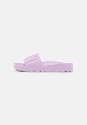 Enkelt lavendel slide-sandal med tekstureret fodseng og justerbar spænde, vist fra siden på en ensfarvet baggrund.
