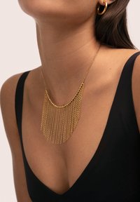 Collar de oro con diseño de flecos en cascada, que presenta eslabones finos de cadena, una parte superior redondeada y un acabado liso y pulido.