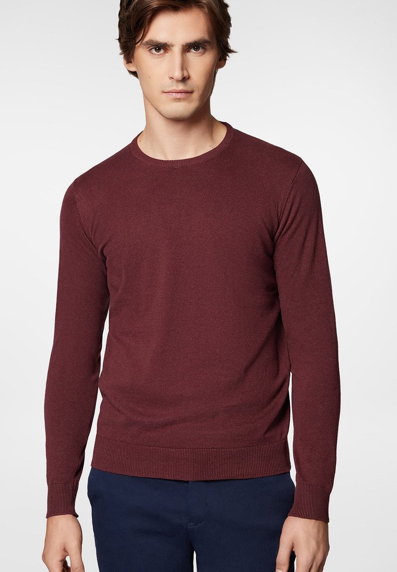 Bordowy sweter z dzianiny z długimi rękawami i okrągłym dekoltem. Ma prążkowane mankiety i obszycie, wykonany z gładkiego, miękkiego materiału.