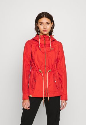 Red lightweight jacket with a drawstring waist, two front pockets, gold accents, and a hood. Smooth texture with a zipper closure.