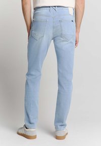 Lichtblauwe denimspijkerbroek met een slim fit, voorzien van twee achterzakken, een tailleband met lusjes voor een riem en een subtiele lichte wassing.