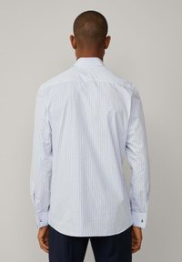 Camisa de vestir a cuadros en azul claro, con mangas largas, cuello y puños abotonados. Tejido suave con una textura lisa y dobladillo curvado.