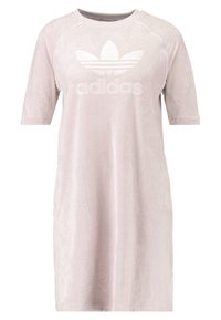 Jasnoróżowa sukienka z krótkim rękawem, wykonana z miękkiego, pluszowego materiału, z białym logo Adidas z przodu i luźnym fasonem.