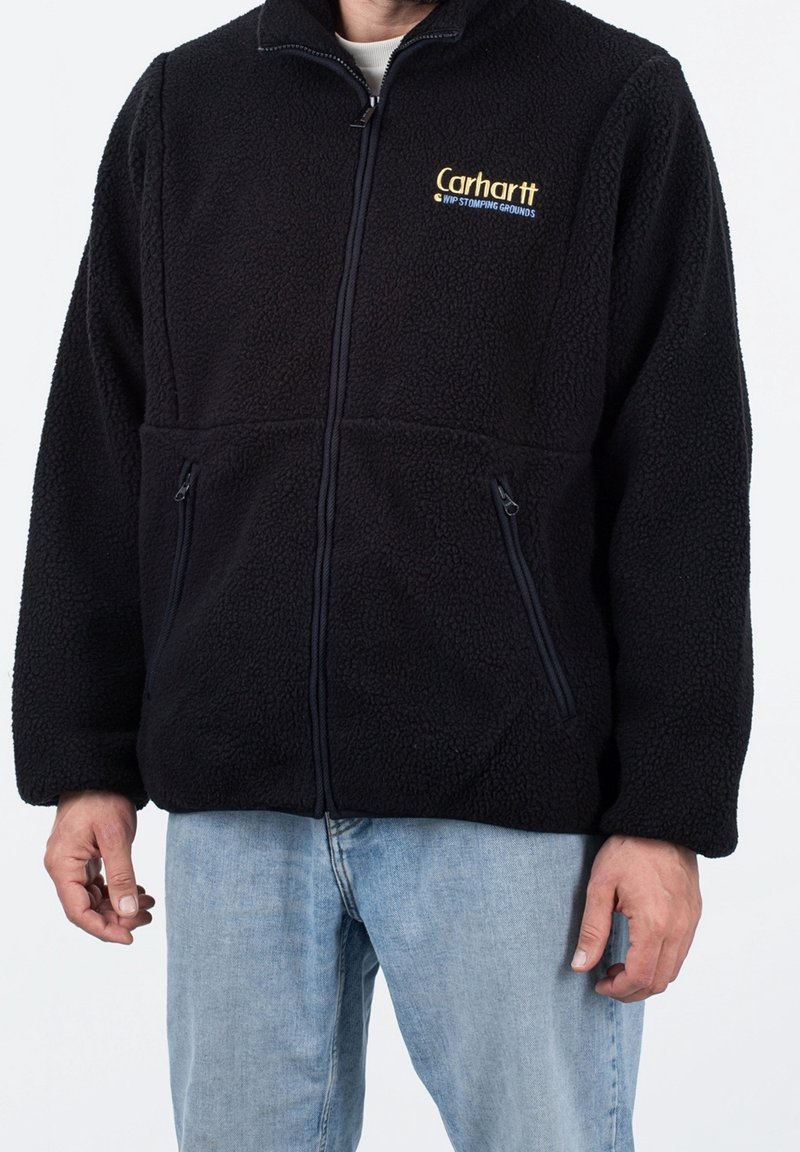 Czarna polarowa kurtka z zamkiem błyskawicznym, dwoma przednimi kieszeniami i wysokim kołnierzem. Wykonana z teksturowanego materiału, z małym logo na piersi.