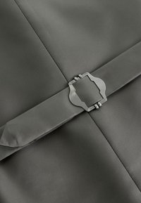 Dark gray fabric with a matching belt featuring a geometric metal buckle centered on a seam intersection.