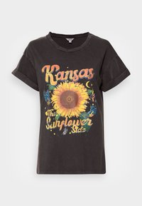 Camiseta de algodón negra de manga corta con un gráfico colorido de un girasol, el texto "Kansas" y "El estado del girasol" en un estilo vintage.