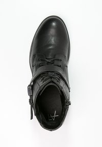 Stivale alla caviglia in pelle nera con punta arrotondata, chiusura con lacci e cerniera laterale per un facile accesso. Fodera interna morbida. Suola piatta.