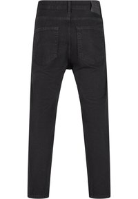 Mustat farkut slim fit -mallilla, joissa on keskikorkea vyötärö, kaksi takataskua ja sileä pinta.