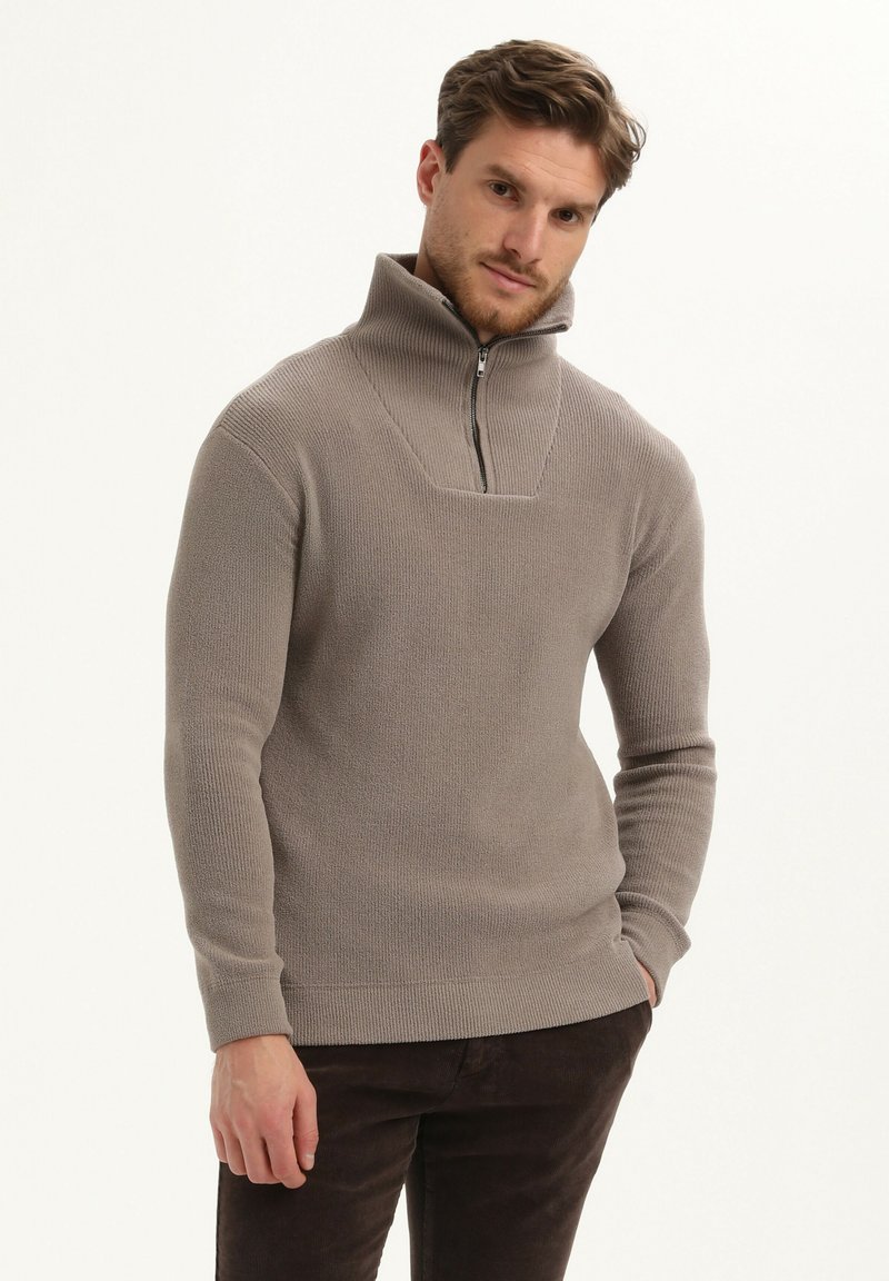 Beige gebreide pullover met hoge kraag en ritssluiting aan de voorkant. Heeft een geribbelde textuur en een vierkant yoke-ontwerp. Slim fit met lange mouwen.