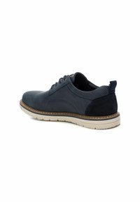 Zapatos de cuero azul marino con acentos de ante y detalles perforados. Cuentan con una suela de goma blanca y un diseño de cordones.