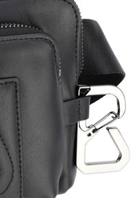 Sort lædertaske med en tekstureret finish, lynlåslukning og justerbar rem. Har en sølvfarvet metalclip til fastgørelse.