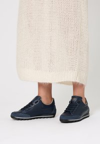 Sneakers in pelle blu navy con finitura texturizzata, design con lacci e un logo discreto sulla linguetta. Suola in gomma per una buona aderenza.