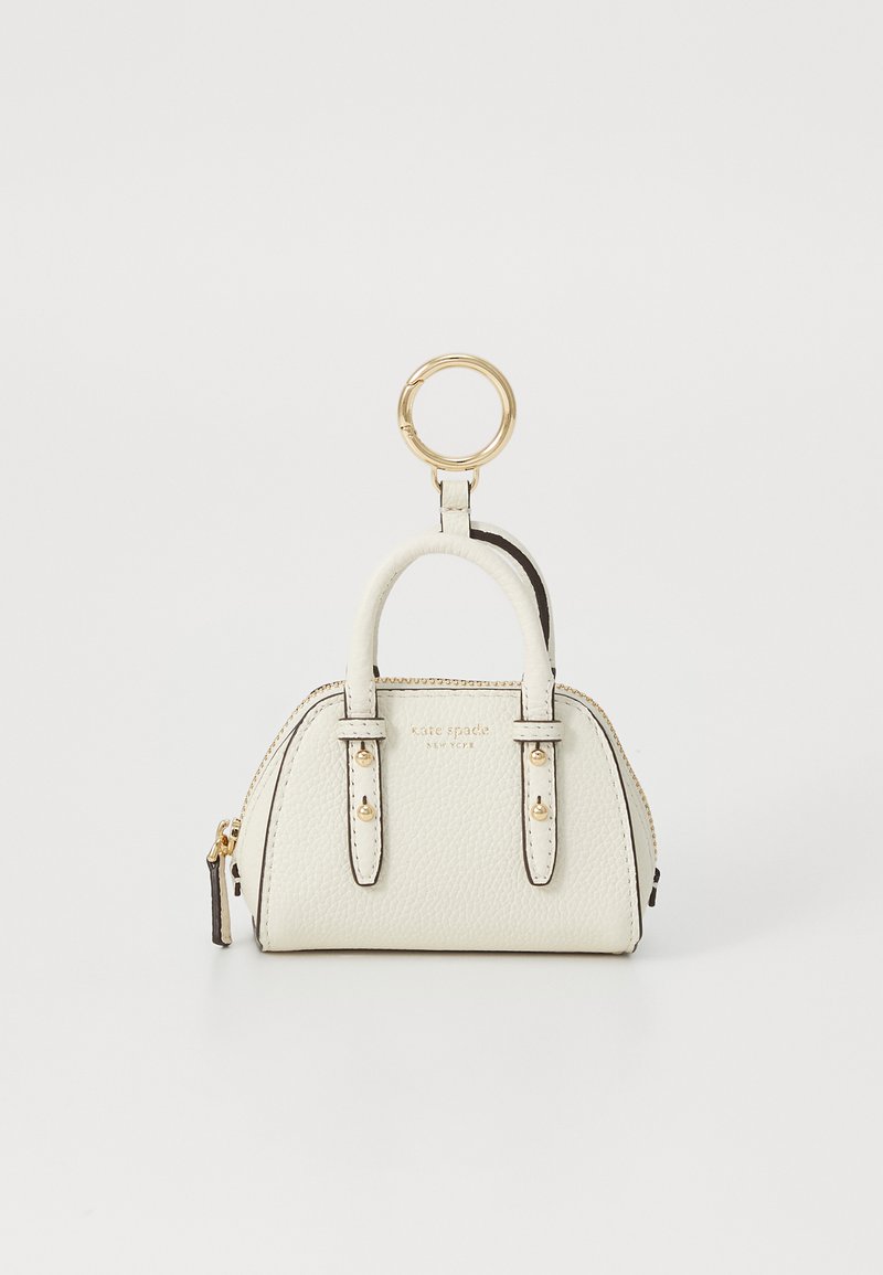 Breloc cu mini geantă de piele crem, echipată cu accesorii aurii și fermoar, cu numele mărcii embosat pe față.