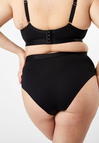 Svart sömlös bh och högmidjade trosor i mjukt tyg, med justerbara band, hake och logoband.