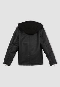Veste en cuir noir accompagnée d'un sweat à capuche noir. Ses caractéristiques incluent des panneaux latéraux côtelés et des poignets zippés, une texture lisse avec une finition mate.