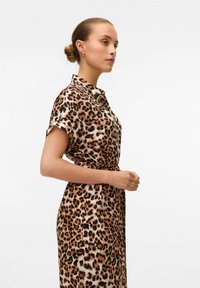 Abito leopardato con maniche corte, colletto a bottoni, cintura in vita e un tessuto morbido e fluido in tonalità marroni e beige.