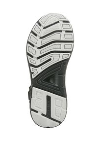 Semelle de chaussure noir et blanc avec un motif de crête en zigzag. Surface en caoutchouc texturée avec des zones de grip définies et un logo de marque bien en évidence.