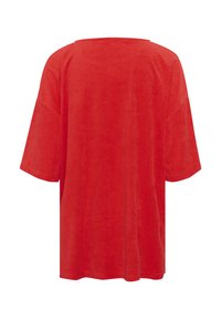 Piros, túlméretezett, rövidujjú felső, puha, sima anyagból, doboz alakú sziluettel és széles, lekerekített nyakkivágással.