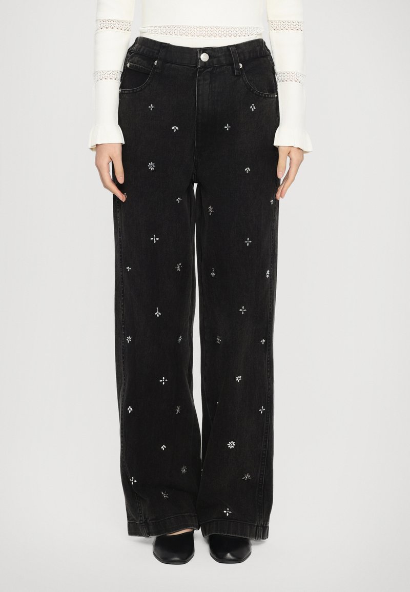 Black denim wide-leg trousers featuring silver floral and geometric embroidery, with a classic five-pocket design and button closure.
