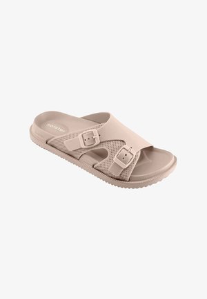 Beige open-toe slide sandal with two adjustable buckle straps and textured sole, designed for casual wear.