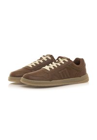 Zapatillas de cuero marrón con cordones beige y suela de goma. Presentan un diseño curvado, costuras en contraste y tres líneas verticales en el costado.