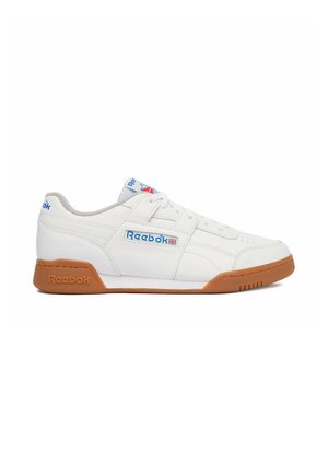 Vit läder Reebok-sneaker med gummisula och blå logodetaljer, sedd från sidan på vit bakgrund.